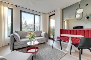 a living room with a red couch and a table at Flamingo Beach Apartment in Gdańsk