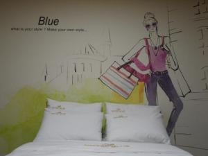 a mural of a woman standing next to a bed at Songdo Blue Hotel in Incheon