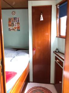 een kleine kamer met een deur en een bed bij B&B Woonschip Robbedoes in Amersfoort