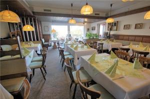 a dining room with white tables and chairs at Lechstedter Obstweinschänke in Bad Salzdetfurth