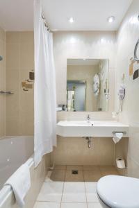 La salle de bains est pourvue d'un lavabo, d'une baignoire et de toilettes. dans l'établissement Qubus Hotel Gorzów Wielkopolski, à Gorzów Wielkopolski