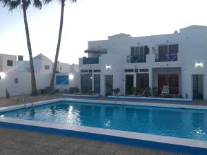 a house with a swimming pool in front of a house at BLU in Puerto del Carmen