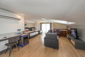 ein großes Wohnzimmer mit einem Sofa und einem TV in der Unterkunft Laren Sea Side Hotel Spa in Antalya