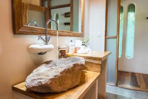 a bathroom with a stone sink and a mirror at Lemala Wildwaters Lodge in Kangulumira