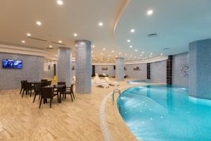 a hotel lobby with a pool and tables and chairs at Yilmazoglu Park Hotel in Gaziantep
