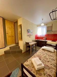 1 dormitorio con 1 cama y cocina con mesa en Ev Roshel Hotel, en Adler