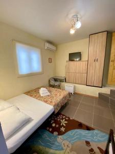 Habitación pequeña con 2 camas y TV. en Ev Roshel Hotel, en Adler