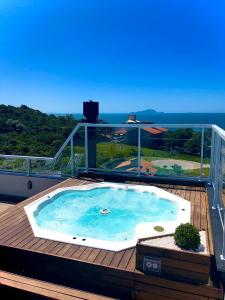 uma banheira de hidromassagem num deque com vista para o oceano em 330 METROS DO MAR, PRAIA DOS INGLESES, Piske Imóveis em Florianópolis