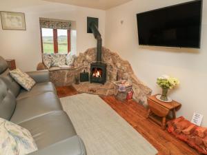 ein Wohnzimmer mit einem Sofa und einem Kamin in der Unterkunft Rushton Barn in Settle