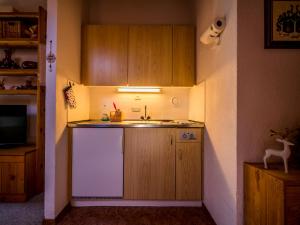 uma cozinha com um frigorífico branco e um lavatório em Appartement cosy au centre de Grimentz em Grimentz