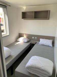 维亚斯Mobilhome Vias plage dans Camping的有两张床和一扇窗户的房间 更多37张照片