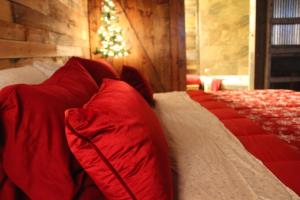 a bedroom with red and white pillows on a bed at The Christmas Cabin in Ozark