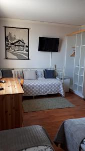 a room with two beds and a flat screen tv at Majoitus Hermanni in Teuva
