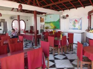 a dining room with red chairs and tables in a restaurant at Pousada dos Corações in Salvaterra