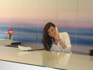 a woman talking on a phone in an office at Hotel Garbi Park & AquaSplash in Lloret de Mar