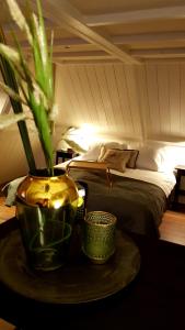a bedroom with a bed and a table with a plant at Hotel dependance Anna's zusje in Harlingen