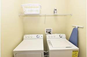 a laundry room with a washing machine and a basket at Holiday Villas of Davenport in Davenport