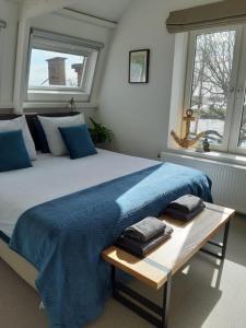 um quarto com uma cama grande e um cobertor azul em Appartement Havenzicht em Enkhuizen