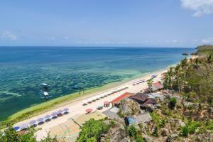 een luchtzicht op een strand met parasols en de oceaan bij OYO 2984 Berlian House Ungasan in Jimbaran