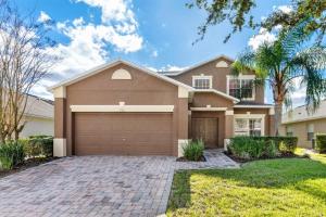 une maison avec un garage et des palmiers dans l'établissement Holiday Villas of Kissimmee, à Kissimmee