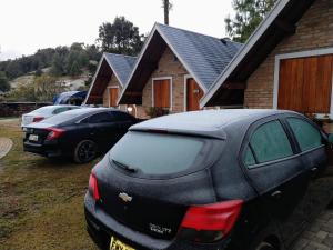 a couple of cars parked in front of a house at Flor da Montanha in Monte Verde