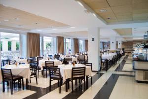 科尼爾－德拉弗龍特拉的住宿－加比光之海岸酒店，一间设有白色桌椅的用餐室