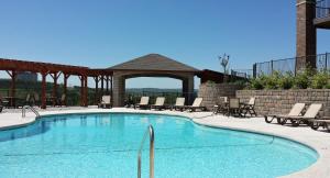 a swimming pool with chairs and a gazebo at Majestic at Table Rock in Branson