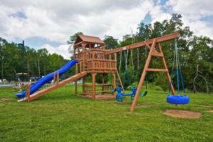 einen Holzspielplatz mit Rutsche und Schaukeln in der Unterkunft Mountain View Condos #3505 in Pigeon Forge