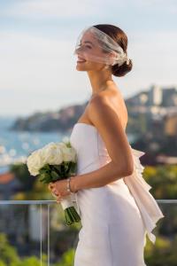 a woman in a white dress holding a bouquet of flowers at InterContinental Sydney Double Bay, an IHG Hotel in Sydney