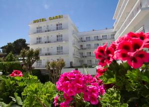 een gebouw met roze bloemen ervoor bij Hotel Villa Garbí in Lloret de Mar