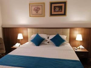 Un dormitorio con una cama grande con almohadas azules. en فندق مزايا, en Az Zāhir