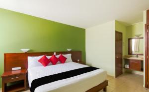 a bedroom with a large bed with red pillows at Hotel San Pablo in Cholula