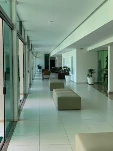 a long hallway with couches and tables in a building at Luxor Tambaù in João Pessoa