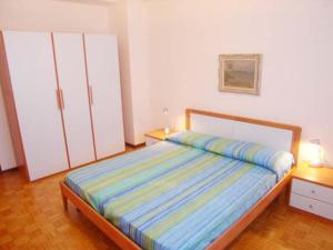 a bedroom with a bed and two white cabinets at Villa Al Mare in Grado +4 photos