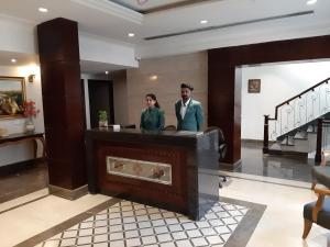 a man and a woman standing at a reception desk at Hotel Golden Tower Near Heritage Street in Amritsar