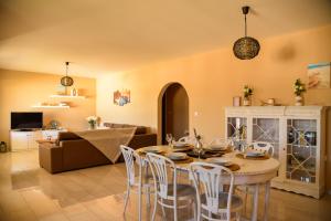 a dining room and living room with a table and chairs at Elegant Apartment in Karpathos