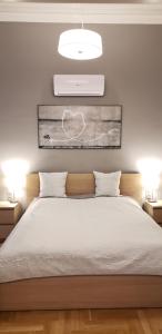 ブダペストにあるSupreme City Center Apartmentのベッドルーム(白い大型ベッド、ランプ2つ付)