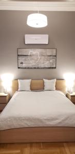 - une chambre avec un grand lit blanc et deux lampes dans l'établissement Supreme City Center Apartment, à Budapest