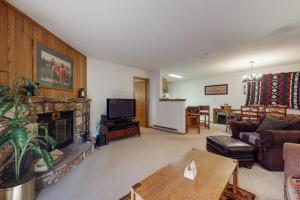 ein Wohnzimmer mit einem Sofa und einem Kamin in der Unterkunft Snowdance Manor 205 in Keystone
