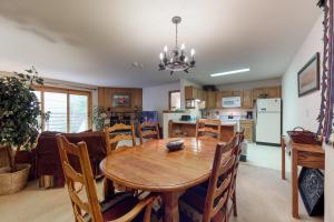 eine Küche und ein Esszimmer mit einem Holztisch und Stühlen in der Unterkunft Snowdance Manor 205 in Keystone
