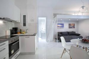 uma cozinha branca e sala de estar com um sofá em Victoria Sq., A cozy and stylish apartment em Atenas