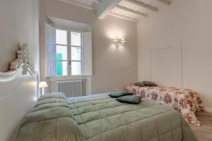 ein Schlafzimmer mit einem großen Bett und einem Fenster in der Unterkunft Lambert Apartment in Florenz