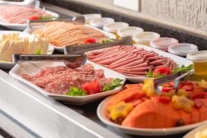 a buffet line with different types of meats and vegetables at Araçatuba Plaza Hotel in Araçatuba