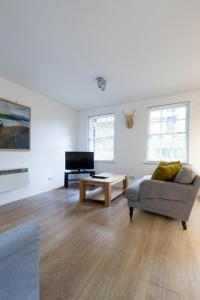 a living room with a couch and a television at Modern Grassmarket Apartment in Edinburgh