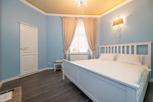 a bedroom with a white bed and white walls at Cathedral Prague Apartments in Prague