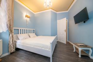 a bedroom with a white bed and white walls at Cathedral Prague Apartments in Prague