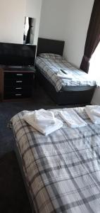 A bed or beds in a room at The Lodge Guest Accommodation 