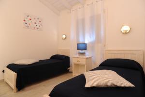 a bedroom with two beds and a table with a lamp at Residence SardegnaSummer Li Mori in Budoni