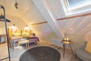 1 dormitorio en el ático con 1 cama y 1 sofá en Chambres d'Hôtes les Colombes, en Montmort-Lucy