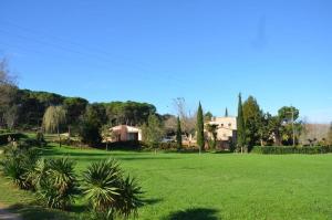 a field of green grass with a house in the background at VILLAS COSETTE Molí d'en Tarrés in Santa Cristina d'Aro